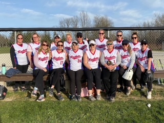 A women's baseball team posing for a team photo.