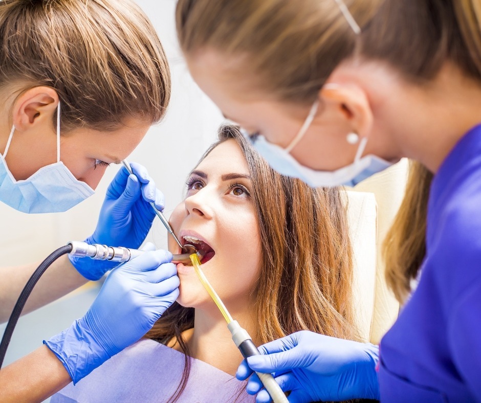 Dentist and assistant treating a patient's tooth
