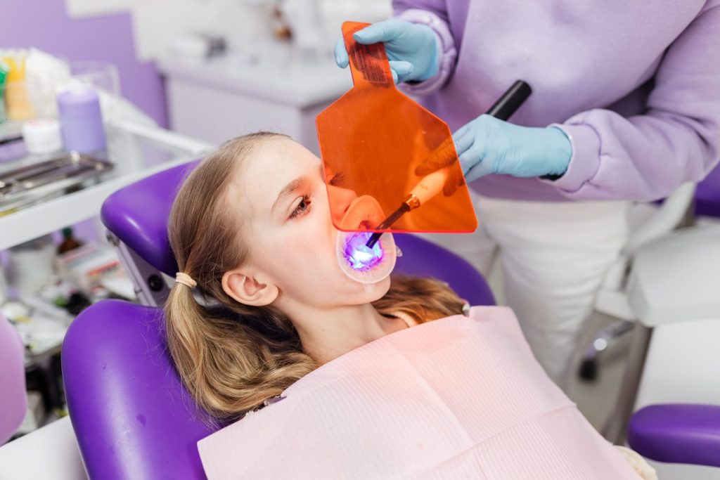 Young girl having a filling set with a curing light