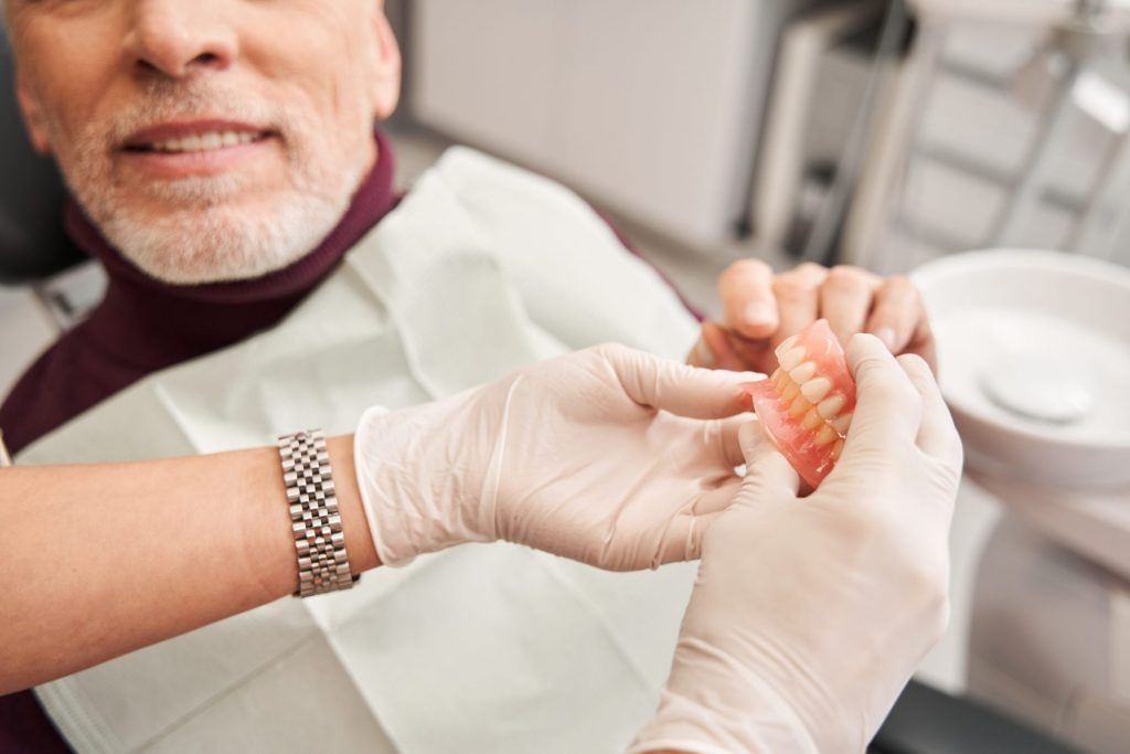 Dentist fitting a partial denture for a senior patient