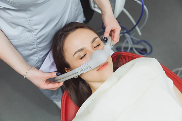 Patient relaxing in the dental chair with a nitrous oxide nose mask