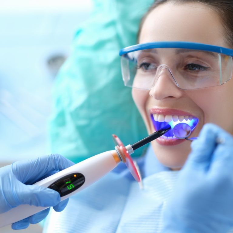 Curing light being used on a patient's teeth
