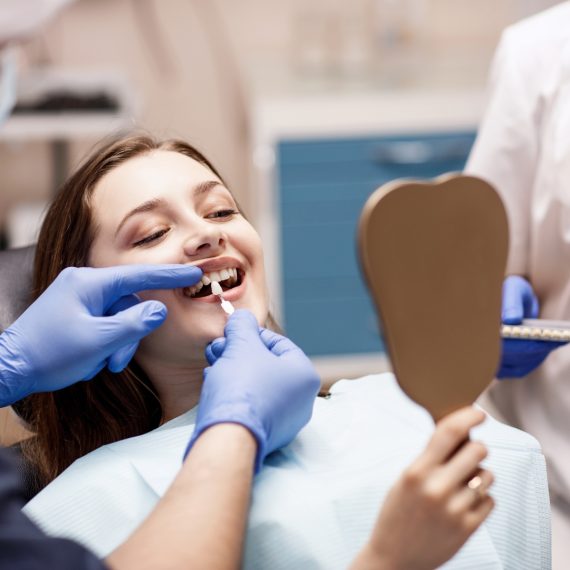 Patient checking her smile in a mirror during treatment